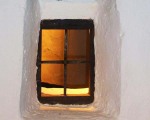 Andalucian window in whitewashed house .